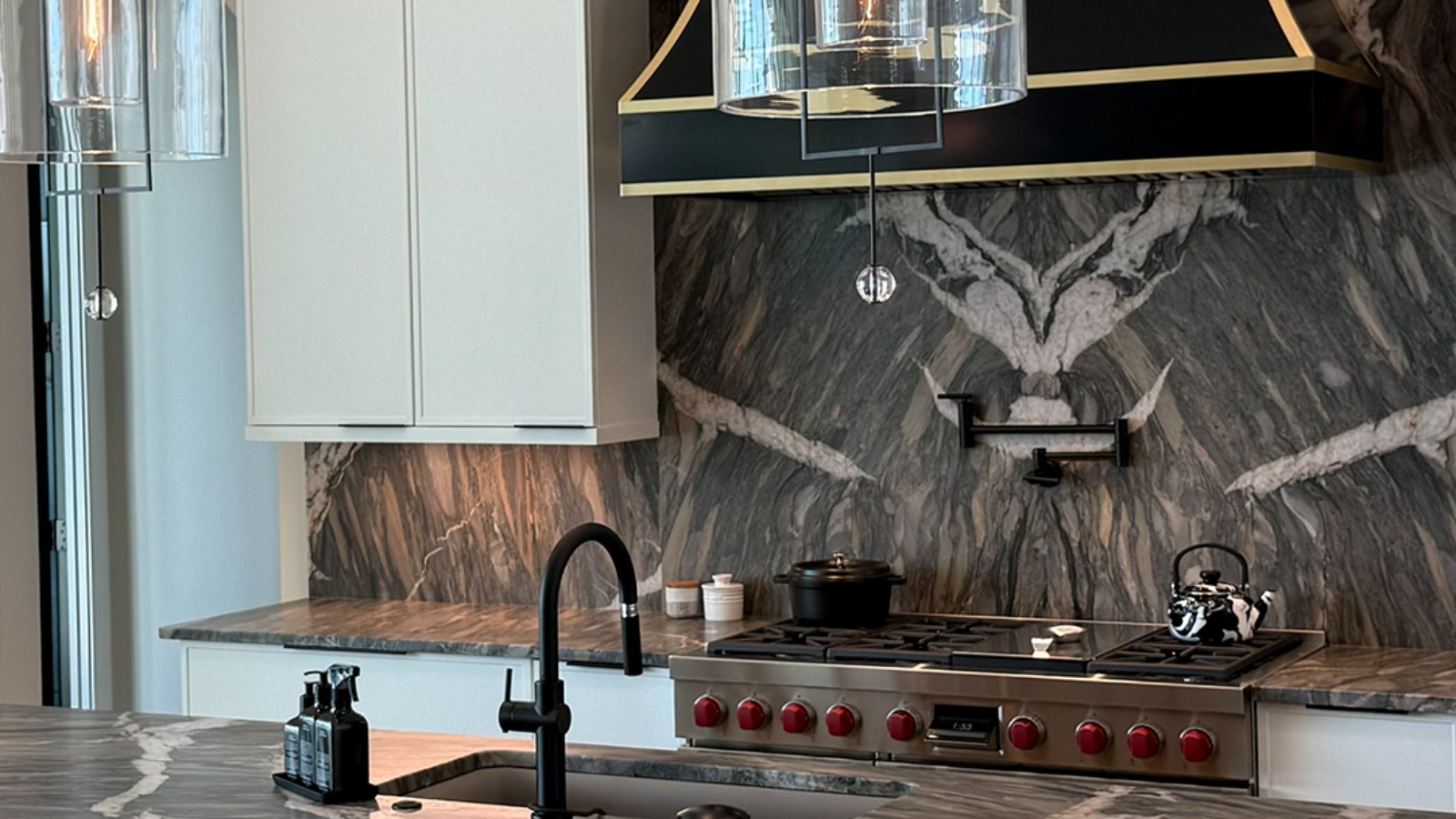 Modern kitchen featuring a dark veined stone backsplash and countertops by HB Marble & Granite.